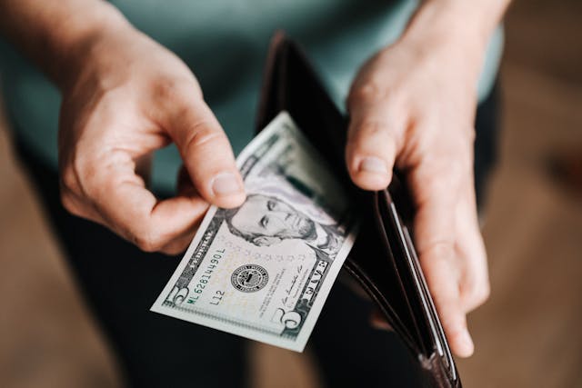 A person taking money out of their wallet