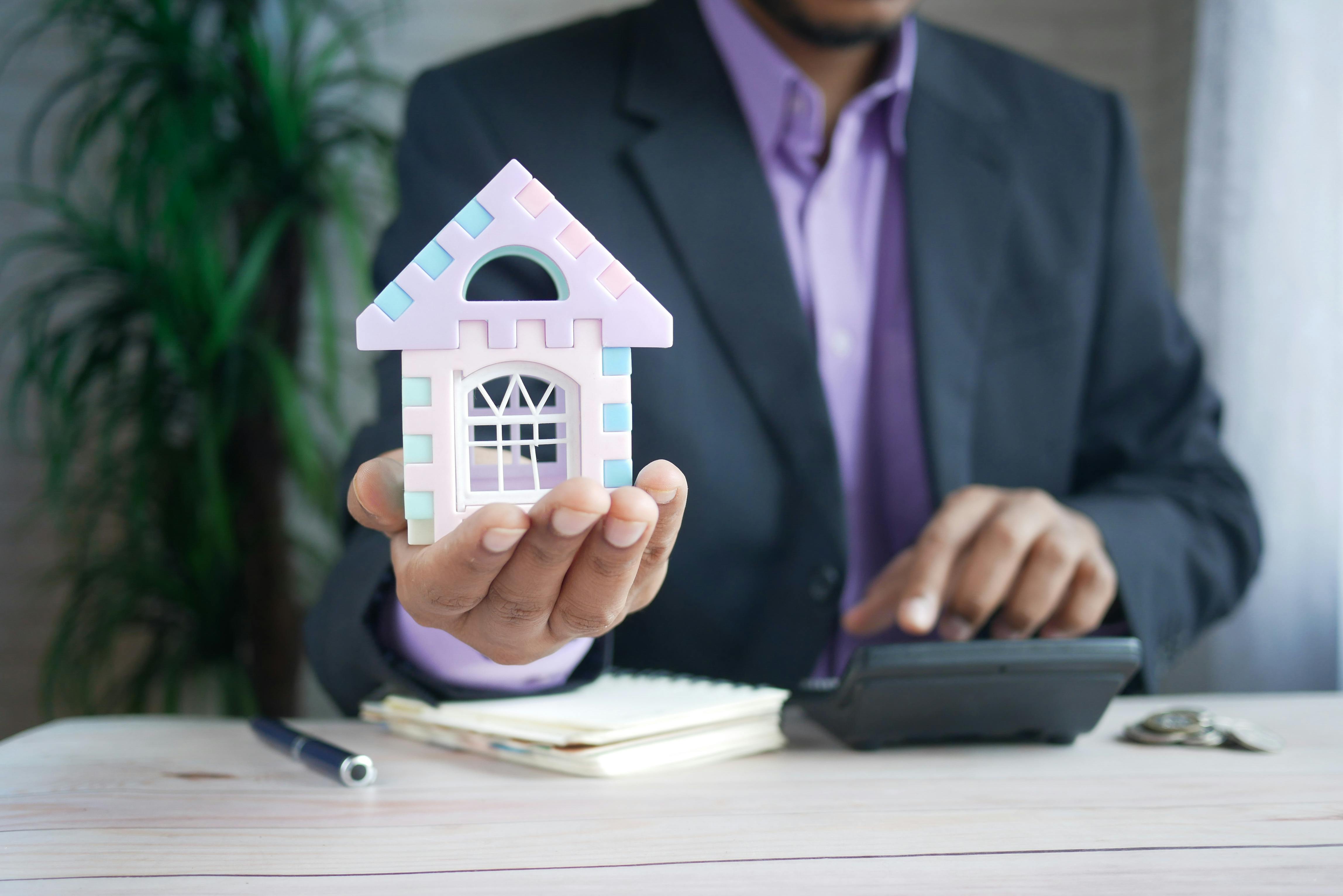 man with house in his hands